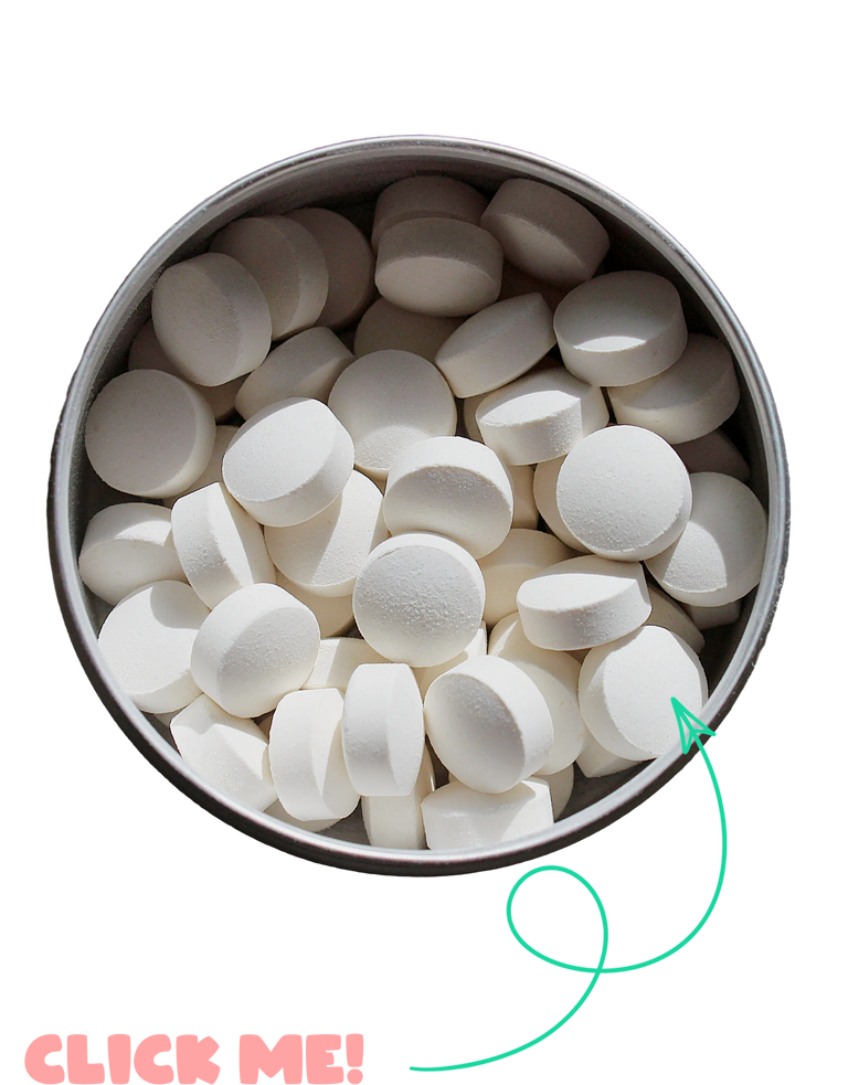 White round tablets piled in a round metal tin, shown on a white background with a green arrow pointing to one tablet and pink text reading 'CLICK ME!'.