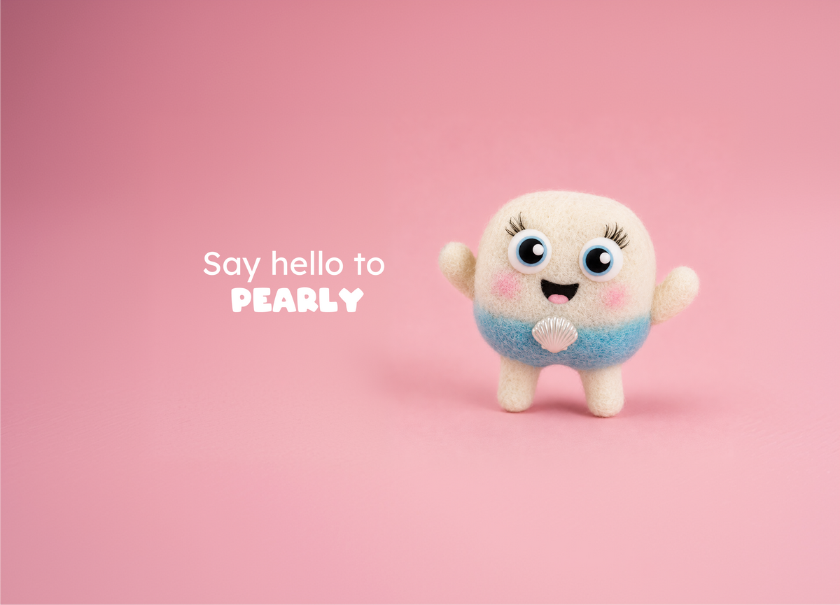A small plush toy character named Pearly stands on a pink background with the text 'Say hello to PEARLY' on the left. The toy is cream-colored on the top half and light blue on the bottom half, with large cartoon eyes, black eyelashes, pink cheeks, and small raised arms.
