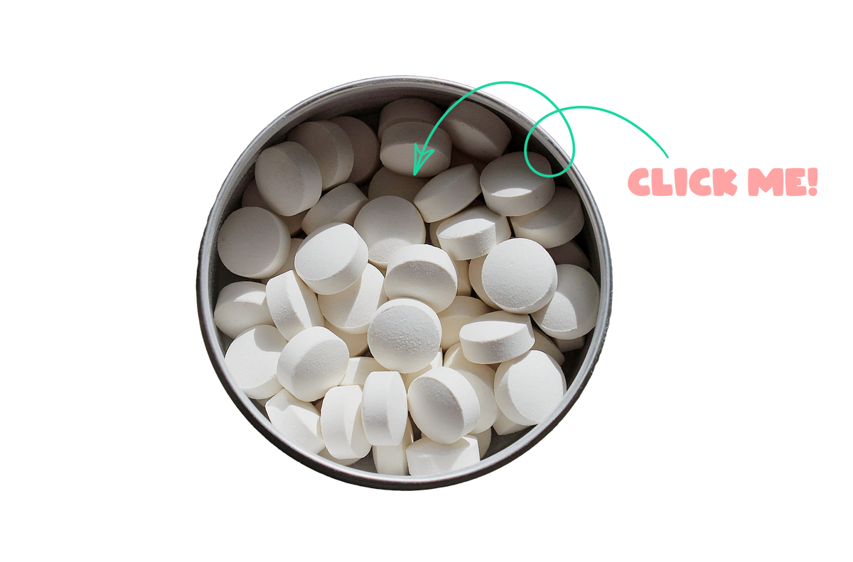 White round tablets piled in a round metal tin against a black background, with a green arrow pointing to one tablet and pink text reading 'CLICK ME!' on the right.